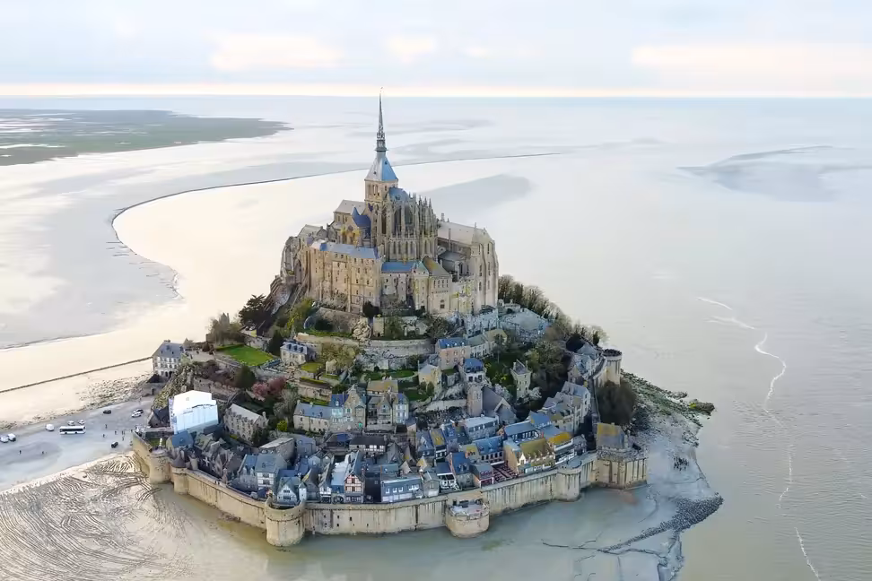 Veduta aerea di Mont-Saint-Michel, con l'abbazia, le mura e il villaggio sulla roccia circondata dalla baia