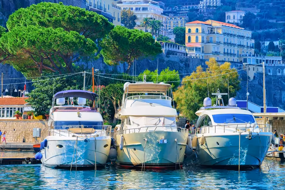 Boats moored under the cliffs and pine trees of Sorrento