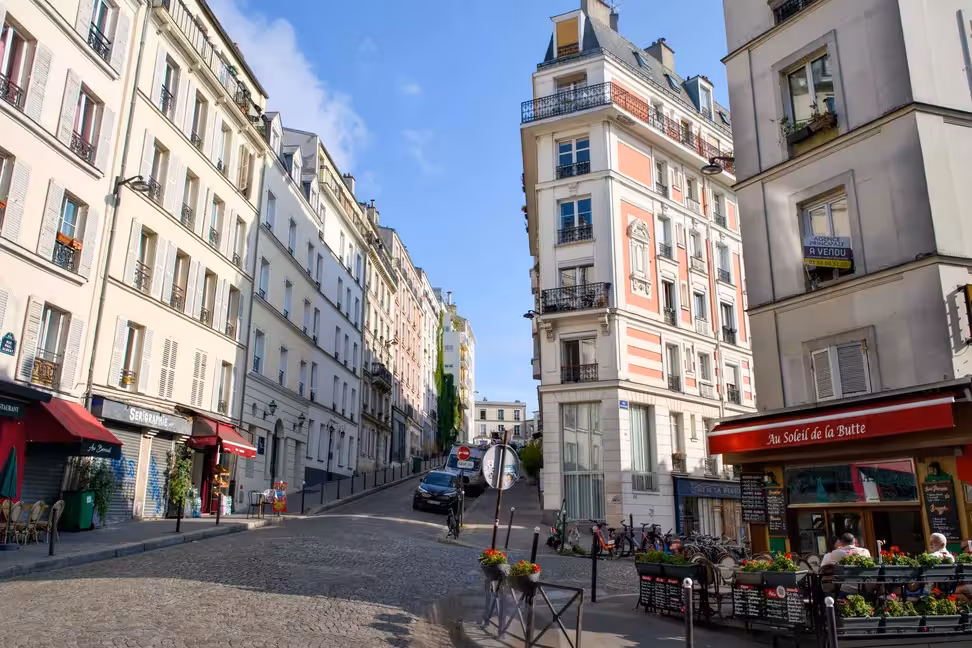 Una strada acciottolata con i tavolini dei caffè a Montmartre