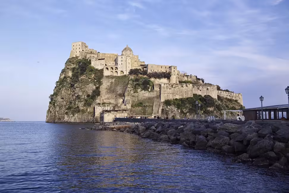 Des promeneurs sur le pont menant au château aragonais, sur son îlot rocheux à Ischia