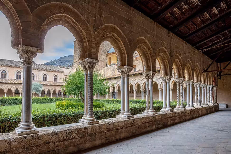 Des colonnes jumelées et des arcs entourent le jardin du cloître de la cathédrale de Monreale