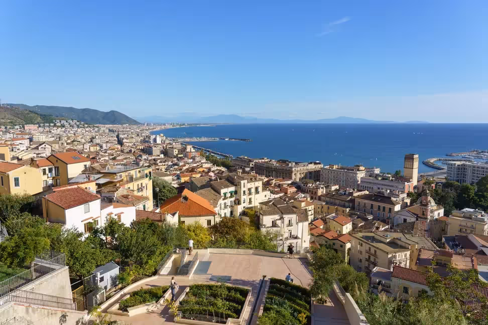 Visiteurs sur une terrasse de jardin dominant les toits de Salerne et son golfe