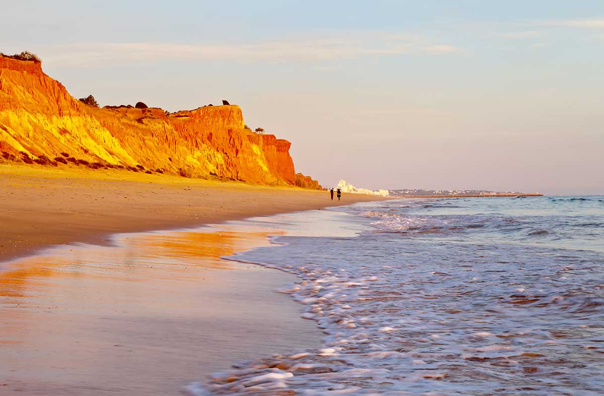 Praia da Falésia, renowned for its dramatic ochre cliffs and golden sands, stretches along the Algarve coastline, attracting visitors with its scenic beauty and offering a picturesque setting for relaxation and coastal walks.