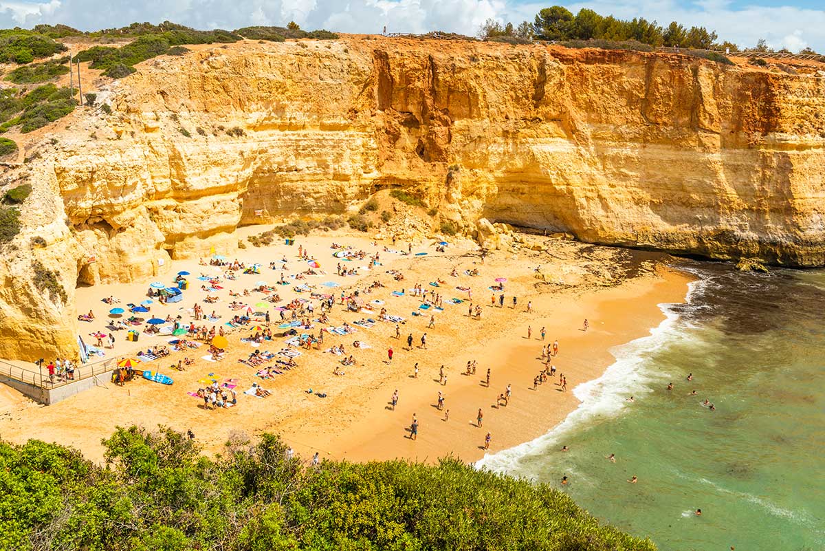Praia de Benagil, famed for its iconic Benagil Cave with its stunning natural skylight, draws visitors to the Algarve coastline for boat tours, kayak excursions, and the chance to witness this unique geological wonder.