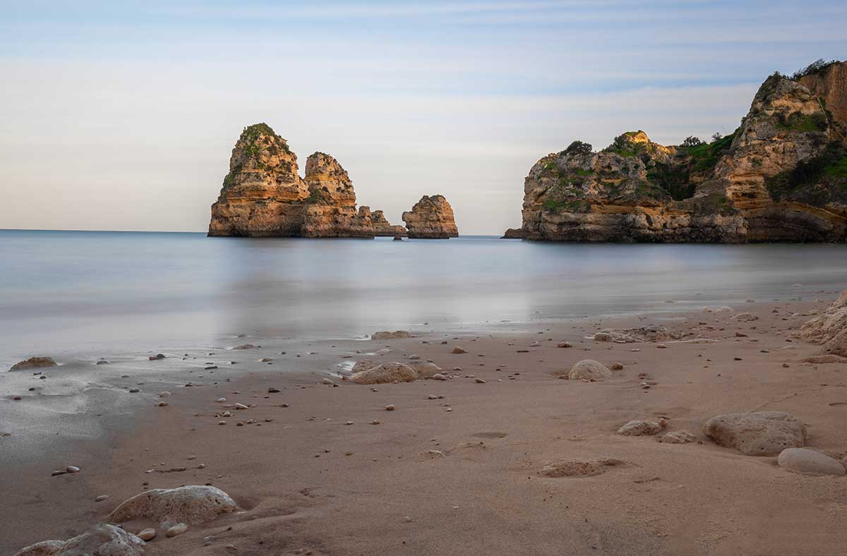 Praia do Camilo, accessible via a long wooden staircase carved into the cliffs, is a secluded Algarve beach celebrated for its intimate coves, golden sands, and crystal-clear waters, making it a popular spot for swimming and snorkeling amidst dramatic rock formations.