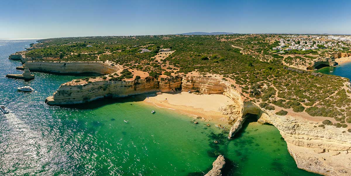 The Algarve's diverse beaches, from the dramatic cliffs of Praia da Marinha and Ponta da Piedade to the hidden coves of Praia do Carvalho and the iconic Benagil Cave, offer golden sands, crystal-clear waters, and breathtaking scenery, making it a premier destination for sunbathing, swimming, and exploring Portugal's stunning coastline.