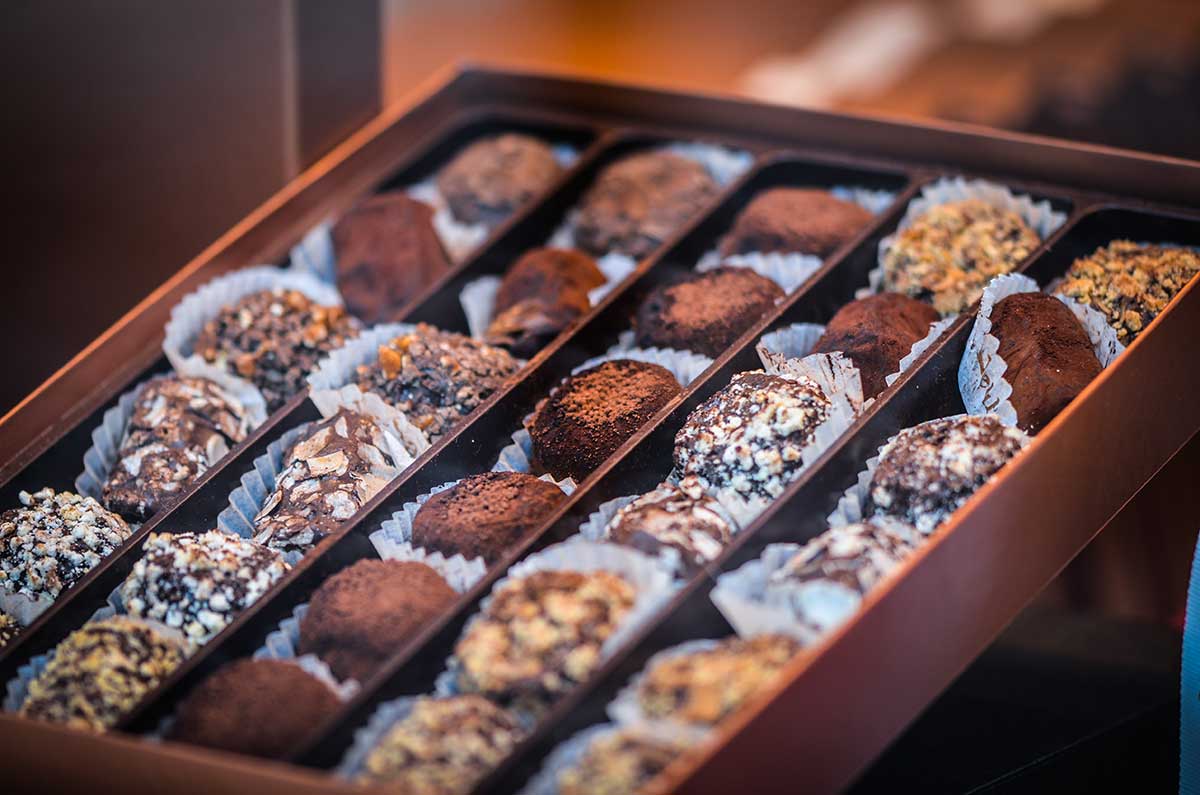 Belgian chocolate, renowned for its smooth texture and rich flavor, is often presented in elegant pralines, truffles, and bars, showcasing the country's mastery of chocolate craftsmanship and culinary artistry.