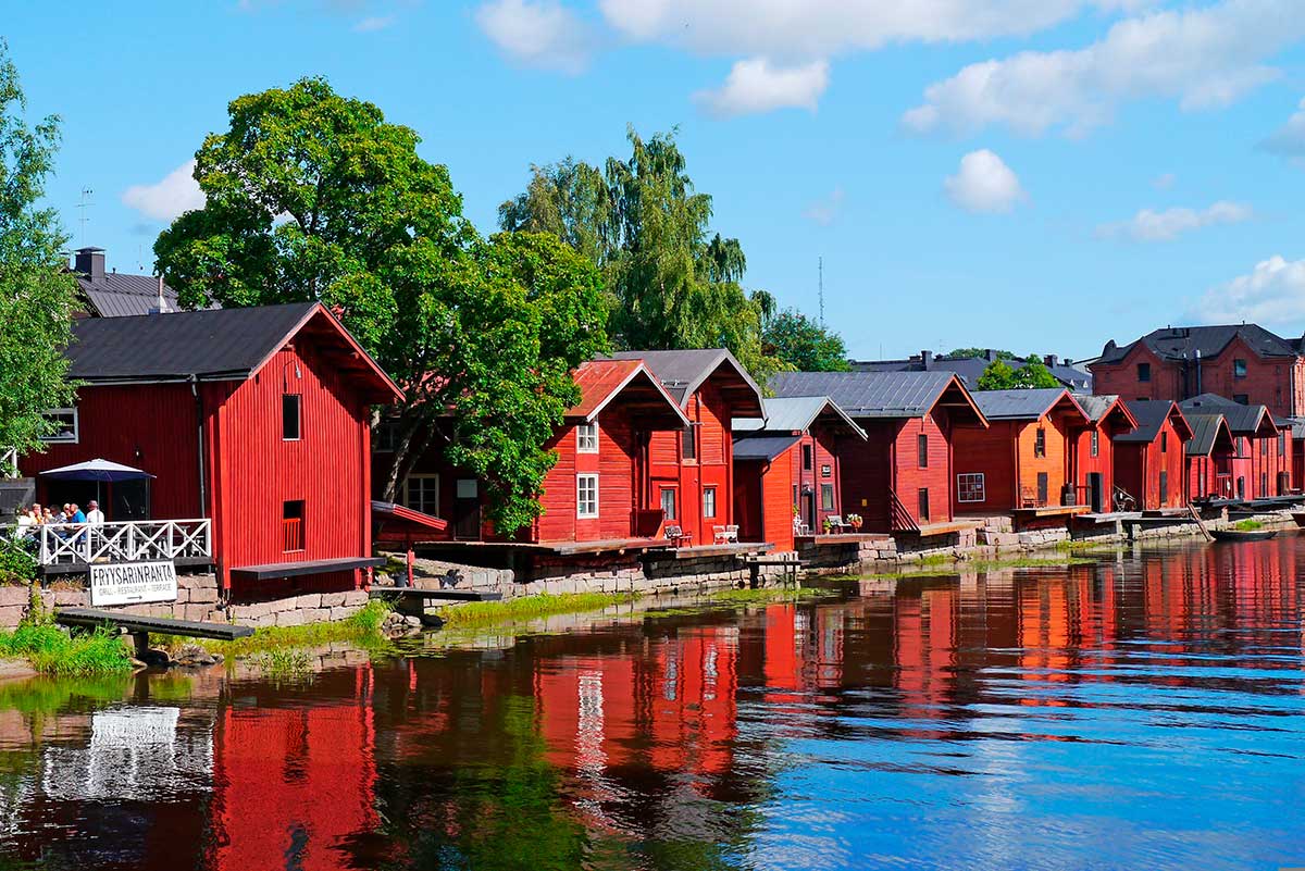 Porvoo, Finland's second oldest town, features colorful wooden houses lining the river, a medieval stone cathedral, and cobblestone streets, showcasing a picturesque historic townscape and charming Finnish architecture.