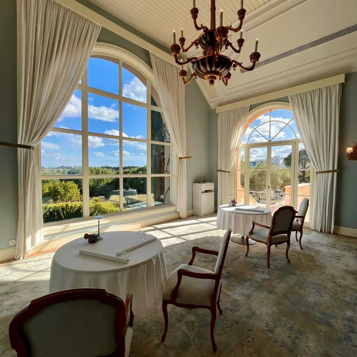 Modern, elegant interior of Vistas Monte Rei, featuring floor-to-ceiling windows overlooking the landscape, highlighting its upscale dining experience.