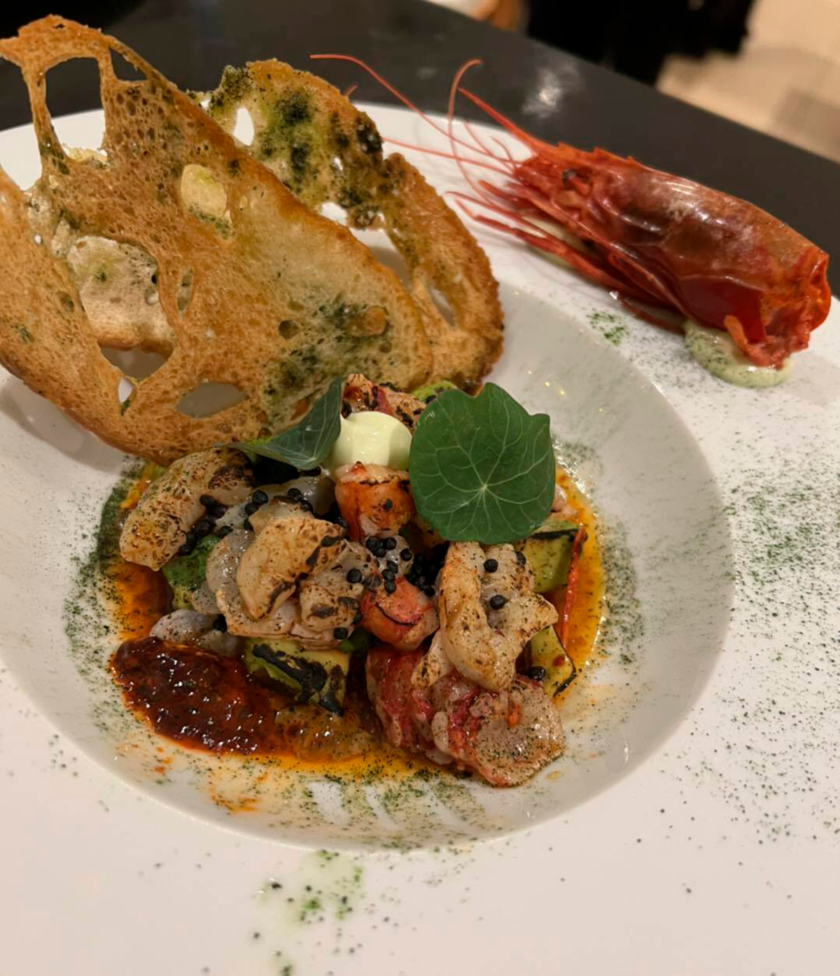 Plates of beautifully prepared seafood at Restaurante Noélia, demonstrating the restaurant's reputation for exceptional regional cooking.