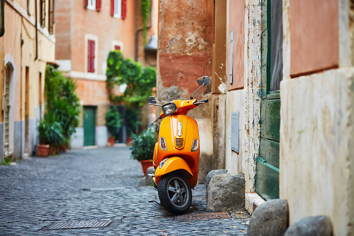 A vibrant street scene in Trastevere, Rome, features cobblestone streets lined with colorful buildings, outdoor cafes, and lively crowds, showcasing the neighborhood's charming, historic atmosphere and bustling social life.