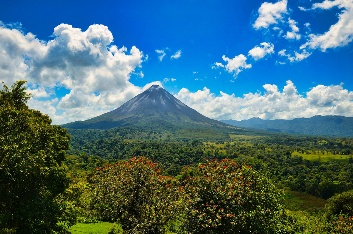 The majestic Arenal Volcano, with its iconic conical shape, dominates the Costa Rican landscape, offering thrilling opportunities for hiking, hot springs relaxation, and breathtaking views of its often cloud-shrouded peak.
