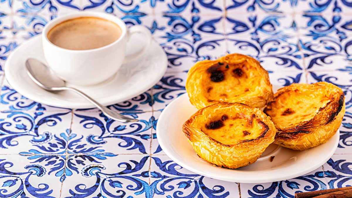 The iconic Pastel de Nata, a quintessential Portuguese pastry, features a crisp, flaky crust filled with a creamy, caramelized custard, often dusted with cinnamon, making it a beloved sweet treat enjoyed worldwide.