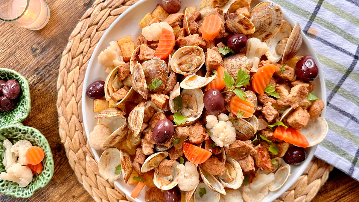 "Carne de Porco à Alentejana," a classic Portuguese dish, masterfully combines tender cubes of marinated pork with flavorful clams, potatoes, and a rich sauce, showcasing the unique and harmonious blend of meat and seafood that defines Alentejo cuisine.