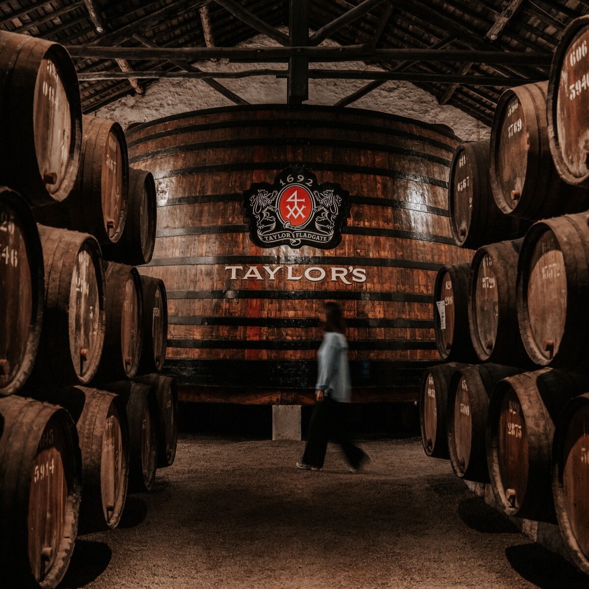 Taylor's Port cellars in Porto, Portugal, feature a historic estate with panoramic views of the Douro River, showcasing aged Port wine barrels and offering guided tours and tastings within a refined, traditional setting.