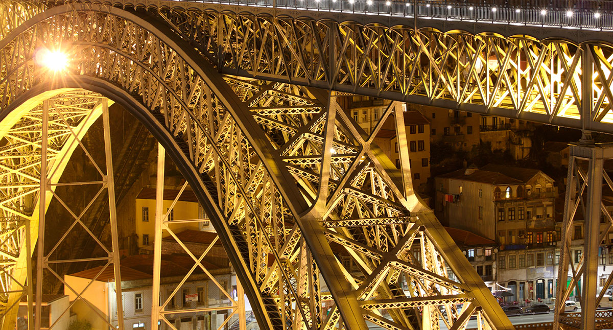 The Dom Luís I Bridge in Porto, Portugal, features a double-deck iron arch spanning the Douro River, offering scenic views of the city and connecting Porto to Vila Nova de Gaia, showcasing its iconic design and engineering.