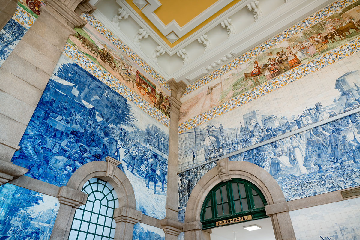 São Bento Railway Station in Porto, Portugal, features stunning azulejo tile panels depicting historical scenes and landscapes, showcasing intricate artistry within its grand, historic train station architecture.