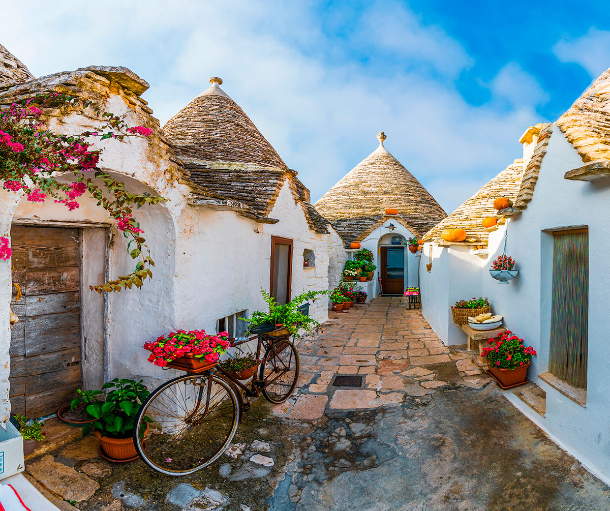 Alberobello, in Apulia, Italy, features unique trulli houses with conical stone roofs, creating a picturesque village landscape, showcasing its traditional architecture and UNESCO World Heritage status.
