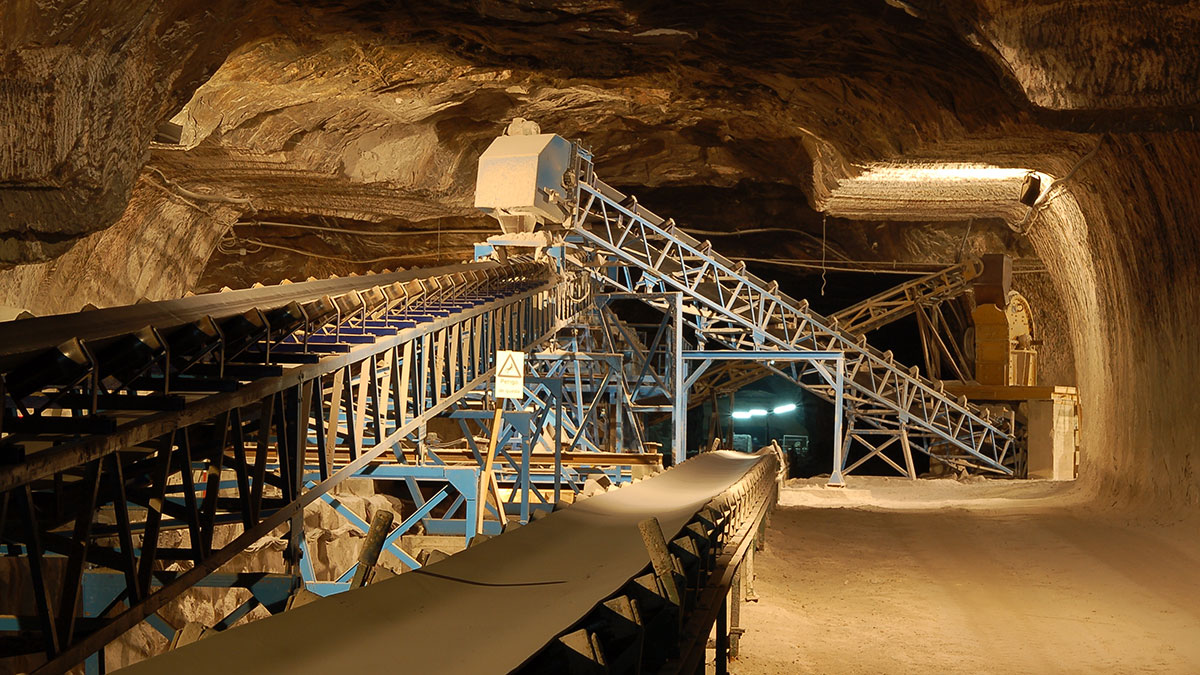 Heavy machinery underground in the Loulé Salt Mine, Portugal, illuminates the vast, excavated salt rock walls, showcasing the industrial scale of salt extraction within the historic mine.