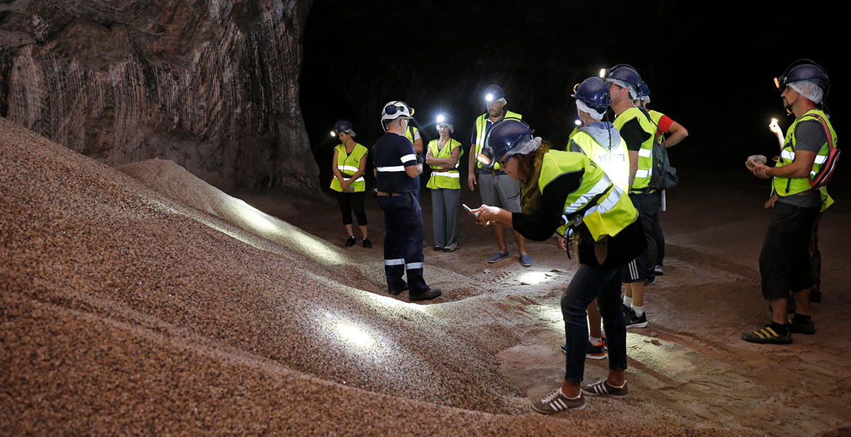 Collecting memories of an underground salt mine features tourists exploring illuminated tunnels, photographing salt rock formations, and learning about the mine's history, capturing the unique experience of a subterranean adventure.