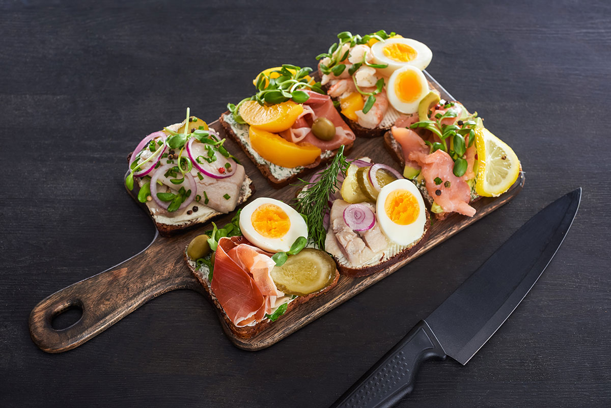 Smørrebrød, a traditional Danish open-faced sandwich, features dark rye bread topped with various ingredients like pickled herring, roast beef, or shrimp, showcasing colorful and artfully arranged toppings that highlight Danish culinary heritage.
