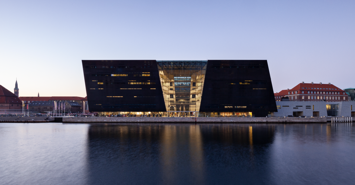 The Black Diamond library in Copenhagen features a modern, sleek design with black granite facades reflecting the harbor, connected to the historic Royal Library, showcasing innovative architecture and a prominent cultural landmark.