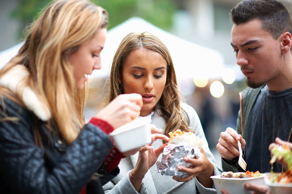 Copenhagen street food markets feature diverse food stalls offering global cuisines, bustling with people enjoying open-air dining, and showcasing a vibrant culinary scene with colorful displays of international dishes.