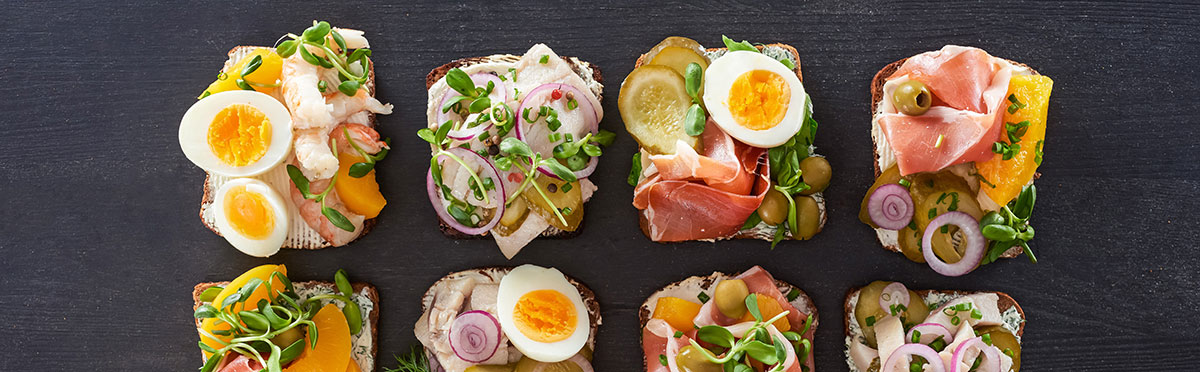 Smørrebrød sandwiches, a Danish culinary tradition, feature open-faced rye bread topped with diverse ingredients like pickled herring, roast beef, and shrimp, showcasing colorful and artfully arranged toppings that highlight Scandinavian flavors.