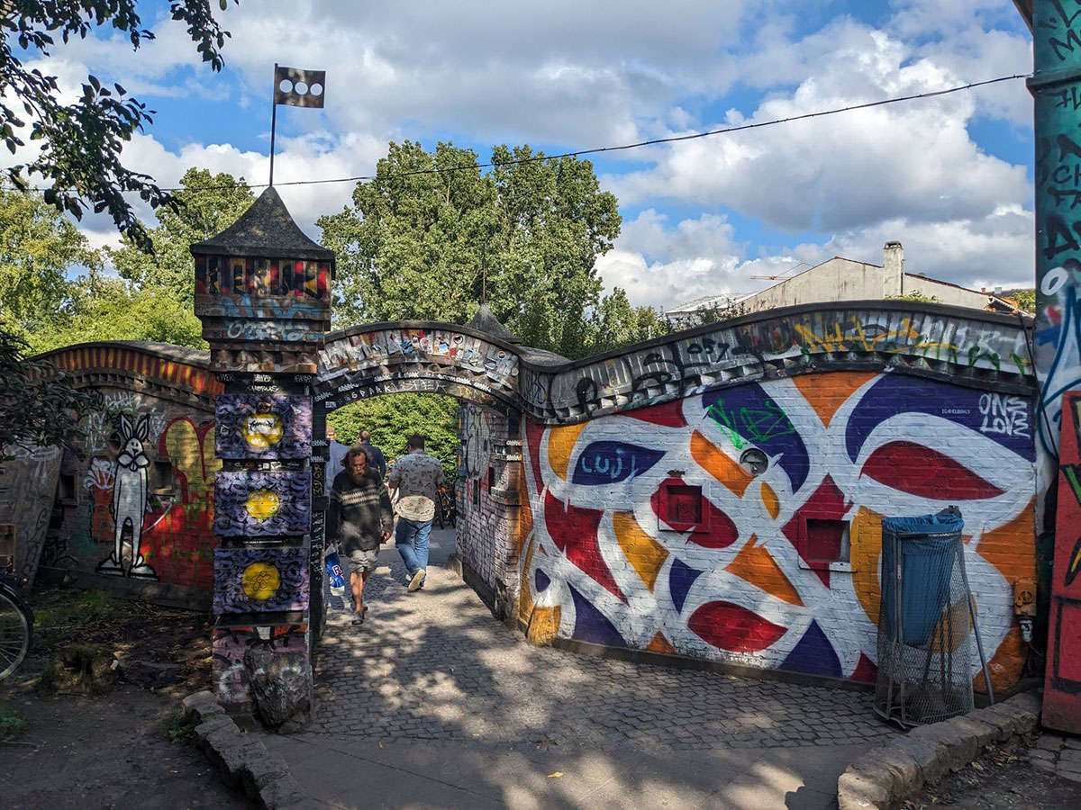 Freetown Christiania in Copenhagen, Denmark, features colorful, self-built houses, lush green spaces, and vibrant murals, showcasing its unique, autonomous community and alternative lifestyle within the city.