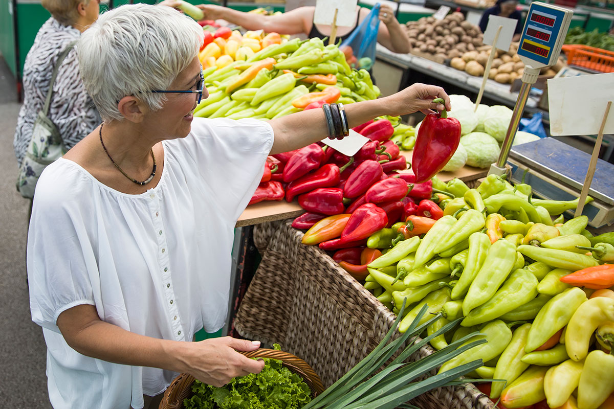 A crowded Île-de-France market, with stands displaying fresh fruits, vegetables, and regional specialties, capturing the essence of local commerce.