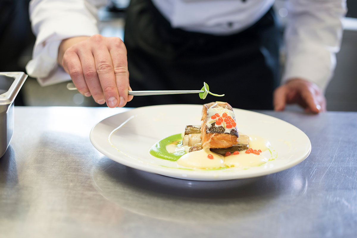 Chef decorating a meal made of fish