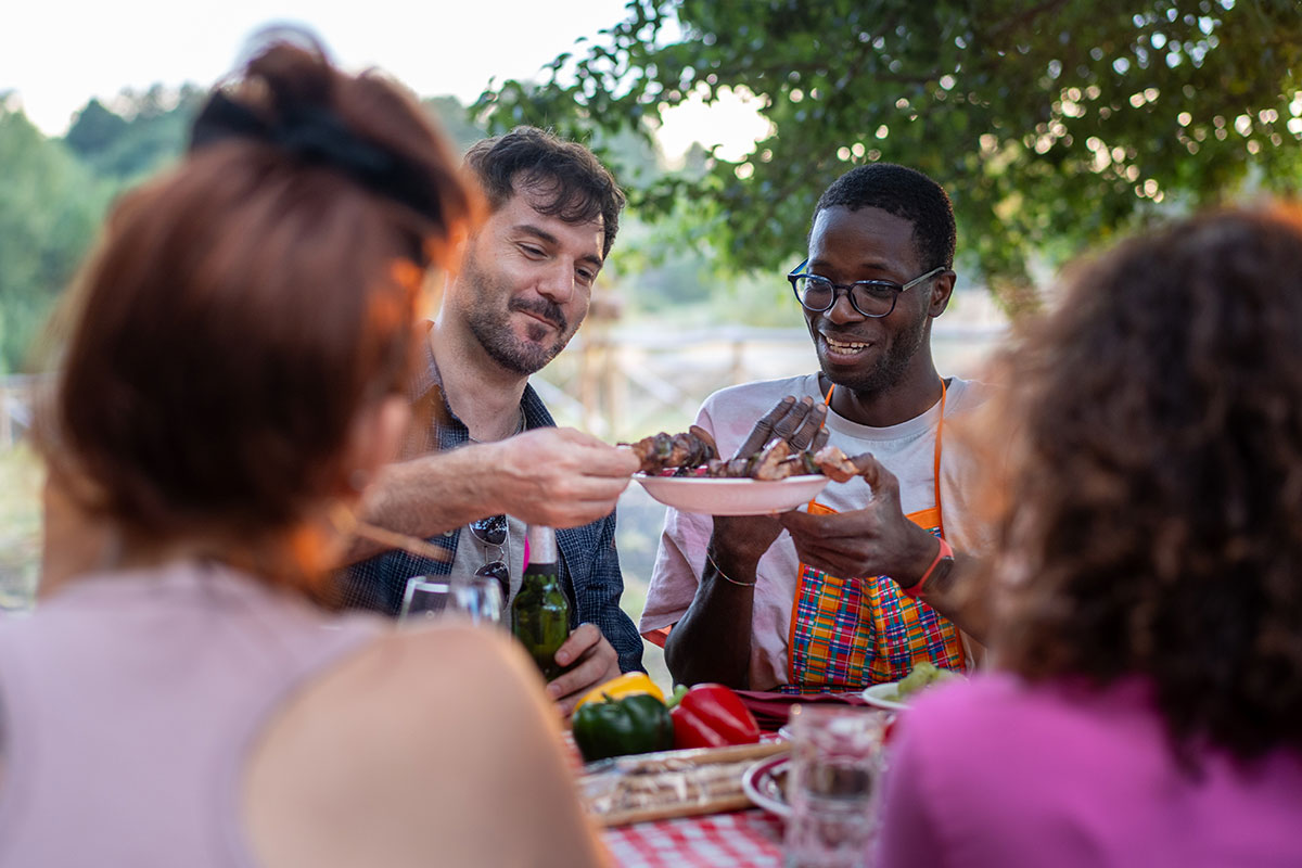 A solo traveler enjoying a meal with local residents at an outdoor market.