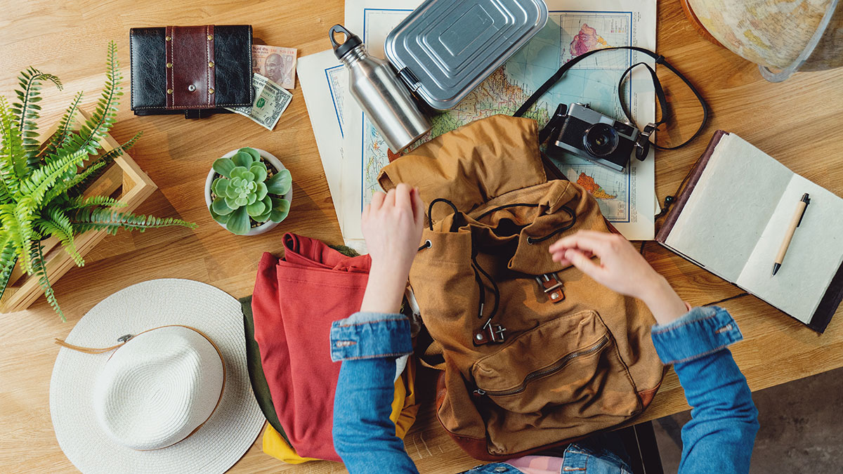 A neatly packed backpack with solo travel essentials like a passport, map, and camera.