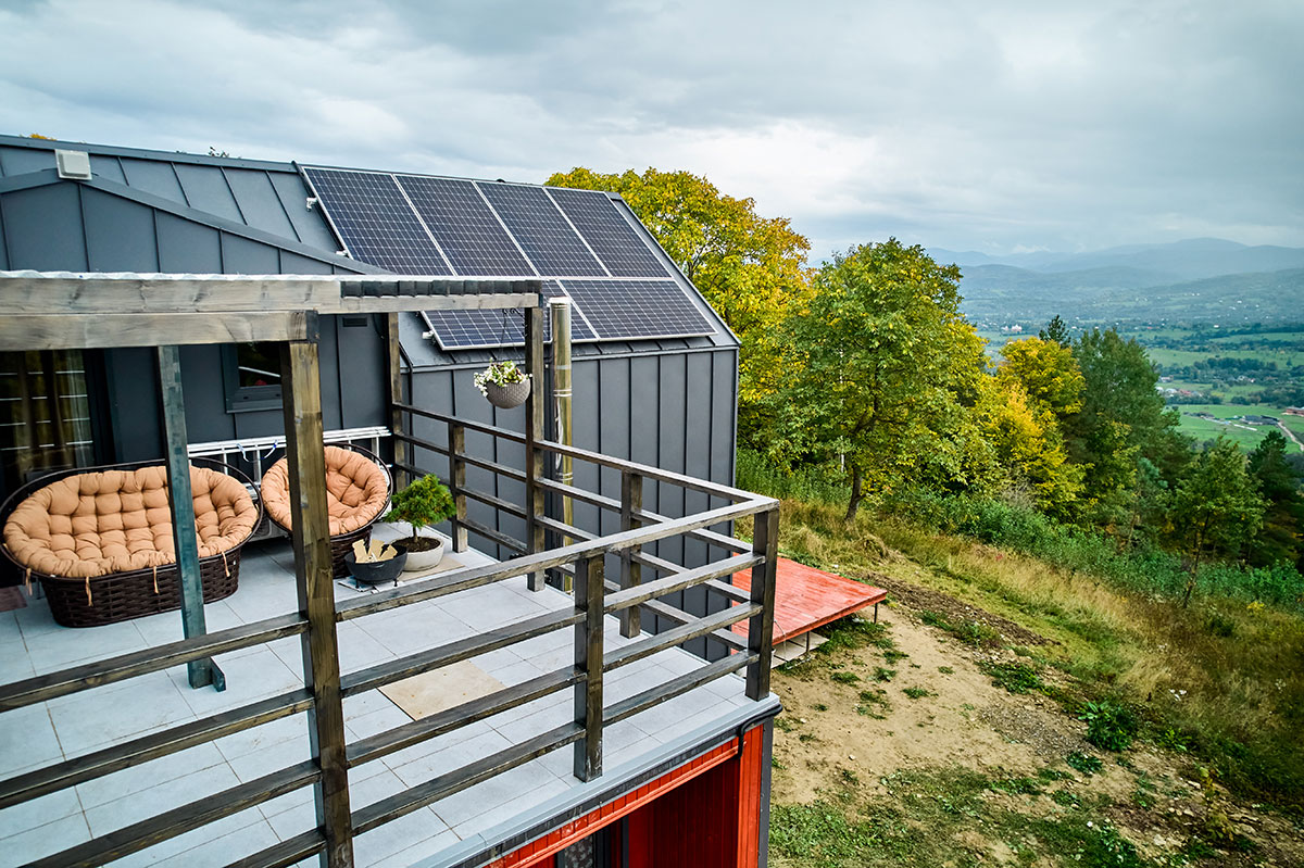 A sustainable budget hostel with solar panels and natural surroundings.