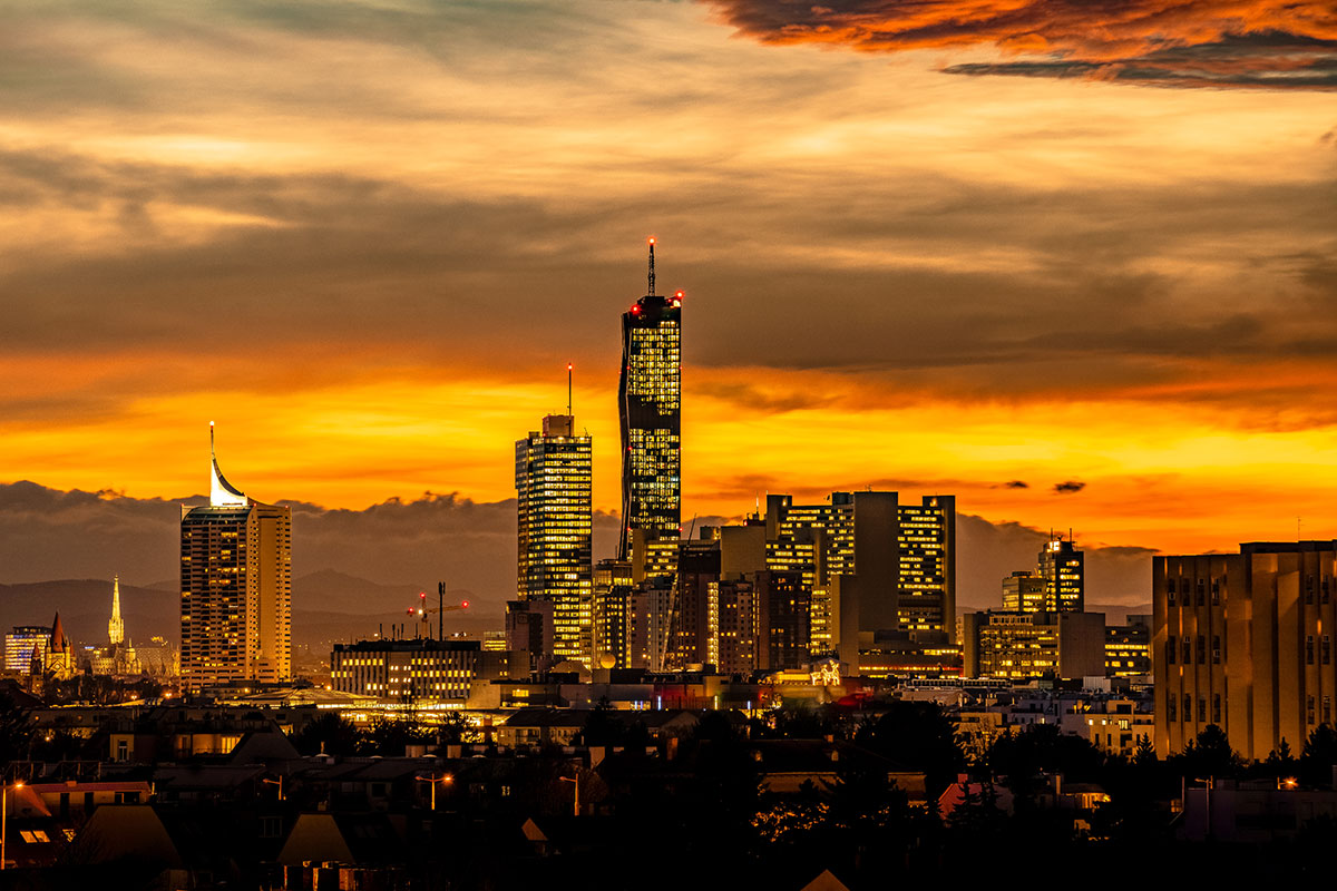A city skyline illuminated by golden hour light, creating a warm, dramatic effect.
