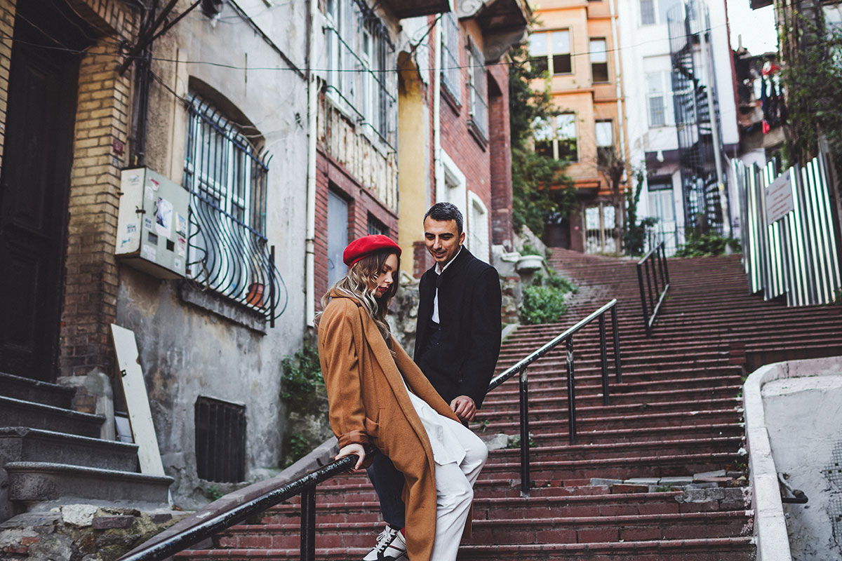 A couple strolling through the cobbled streets of Alfama, Lisbon, surrounded by historic buildings.