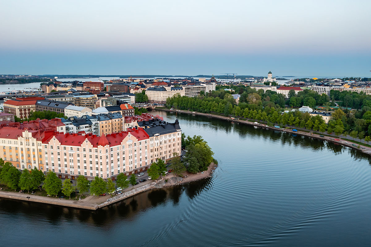 A scenic aerial view of Uusimaa, Finland, showcasing a mix of urban skyline, forests, and the Baltic coastline.