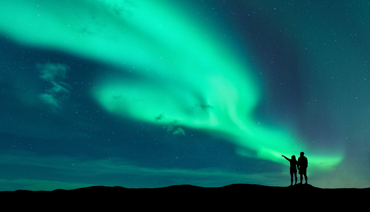Romantic couple watching the Northern Lights in Lapland.