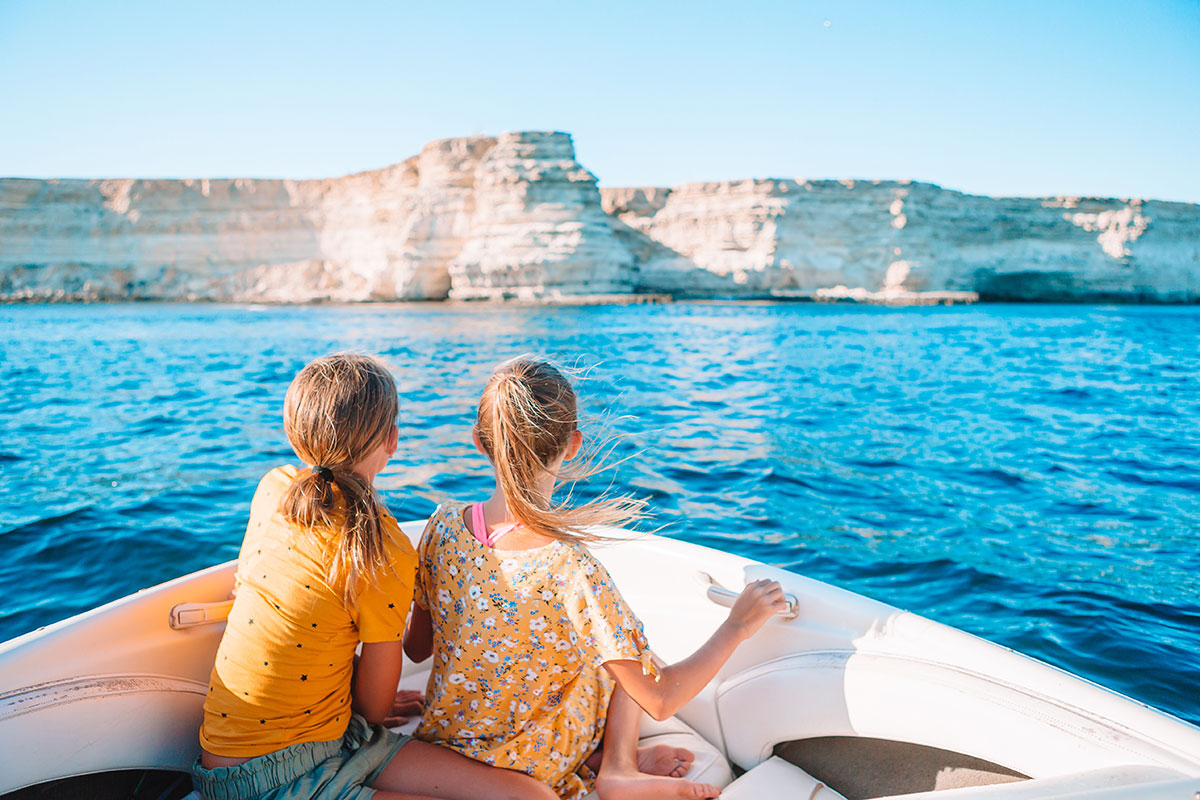 A small boat sailing past Crete’s rugged and secluded south coast.