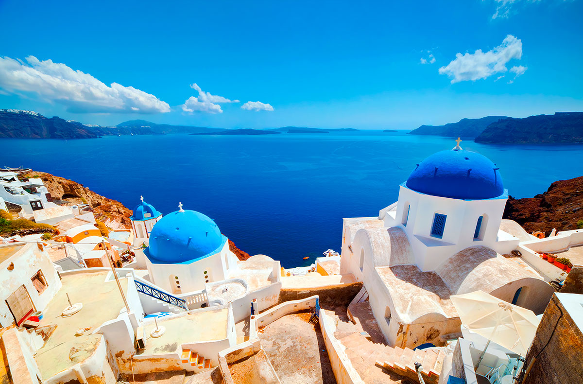 White-washed houses and blue domes of Santorini overlooking the Aegean Sea.