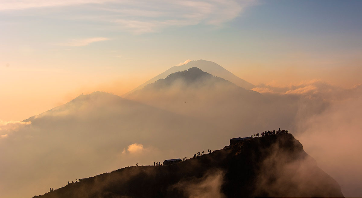 Traveler at the top of Mount Batur during sunrise