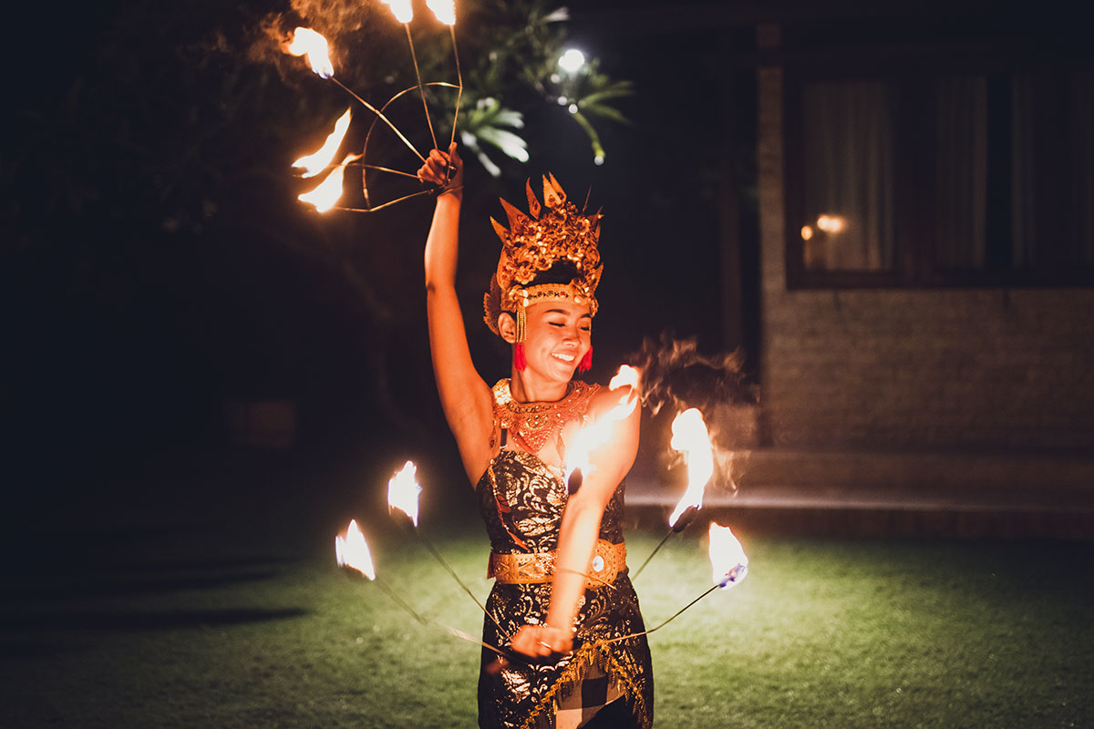 Balinese traditional dancing with fire show at evening beach party