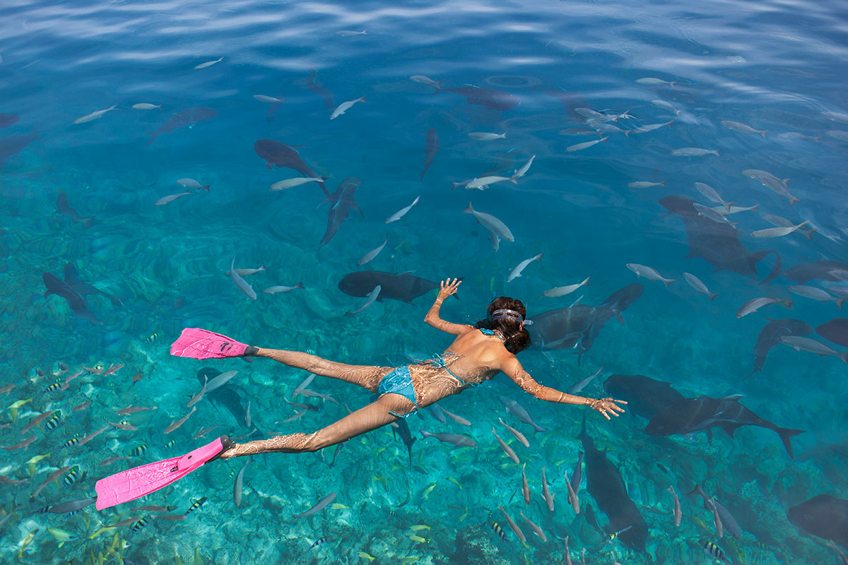 Snorkeler swimming near manta rays in Nusa Penida