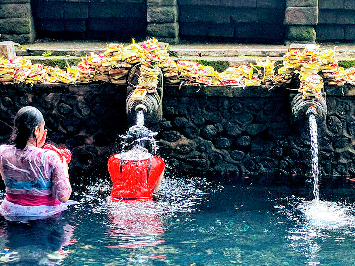 People performing purification ritual at Tirta Empul Temple