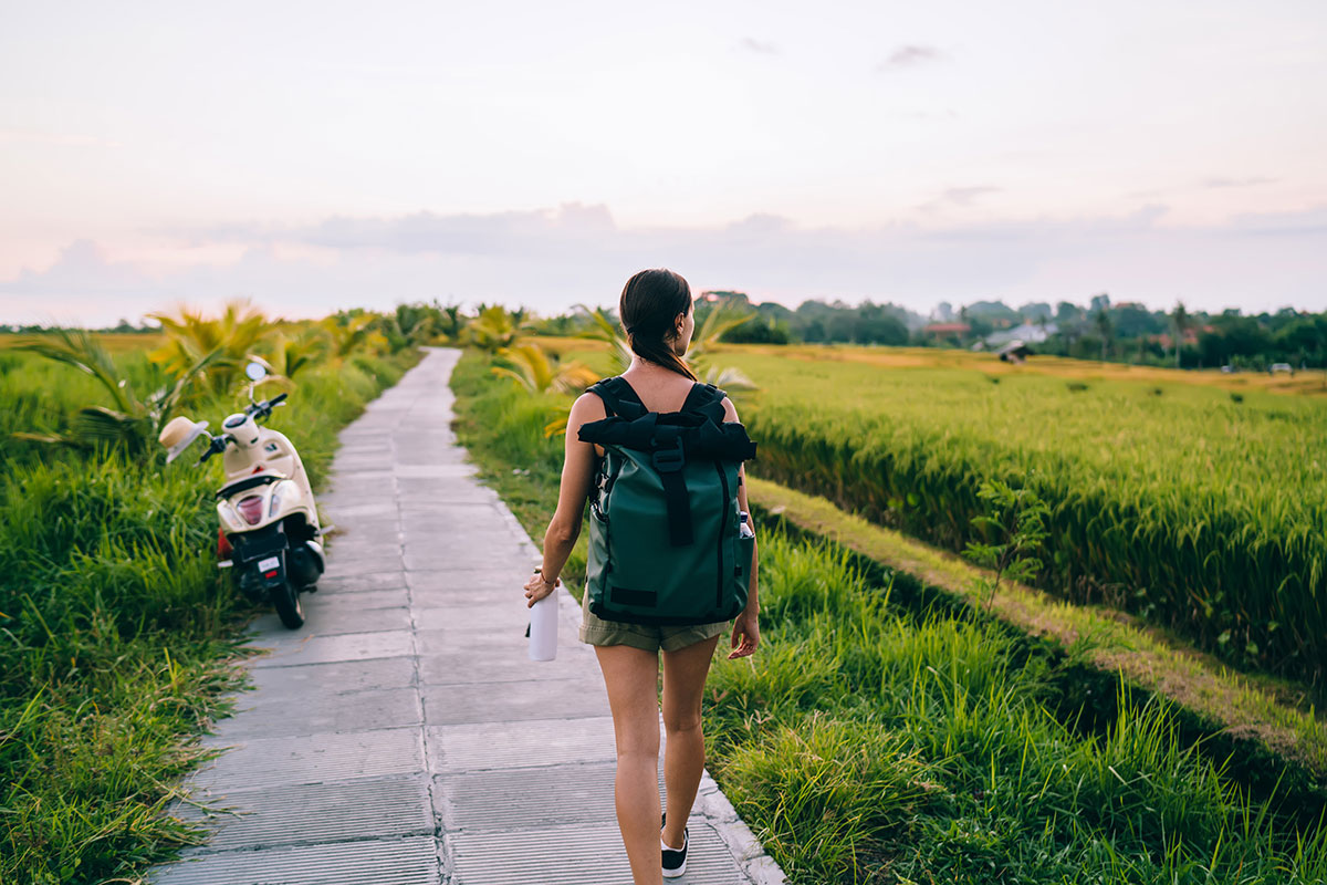 Solo traveler with a backpack and scooter in Bali