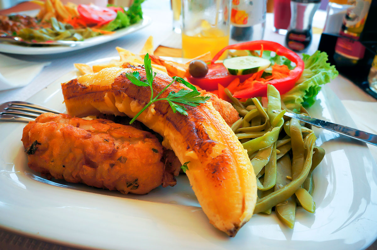 Plate with scabbard fish, fried banana, and bolo do caco bread