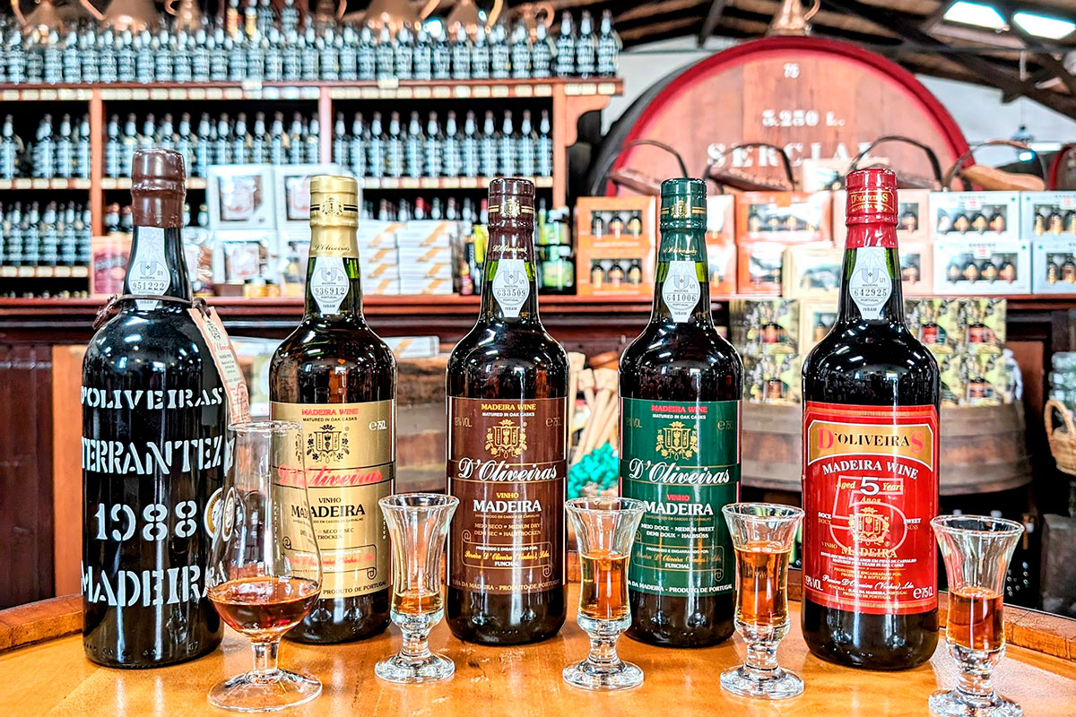 Glass of Madeira wine with barrels in the background at a wine lodge