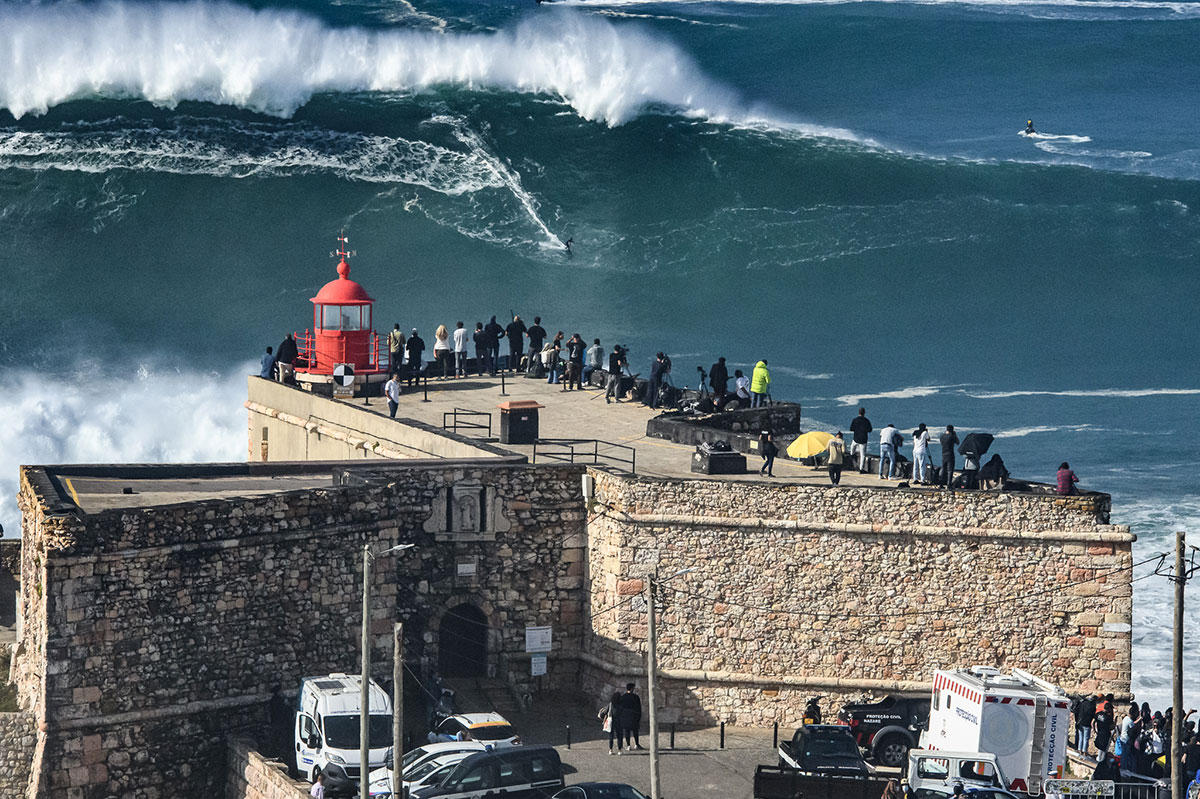 Big wave surfer riding a massive wave at Nazaré, Portugal