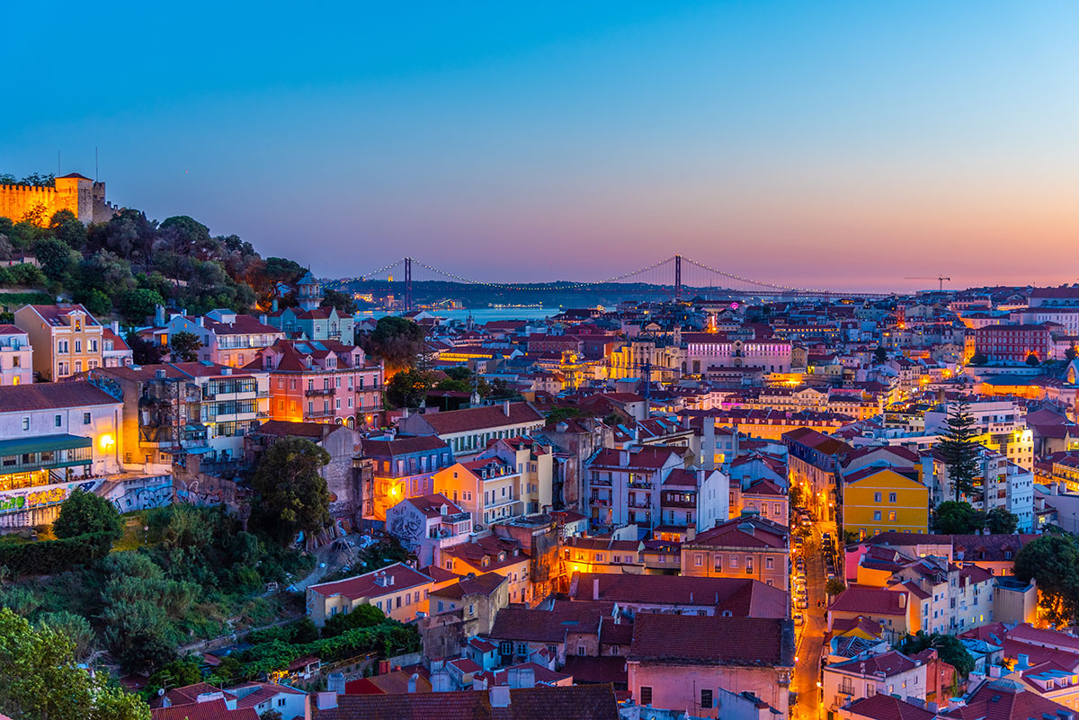 Panoramic view of Lisbon at sunset with rooftops and the Tagus River