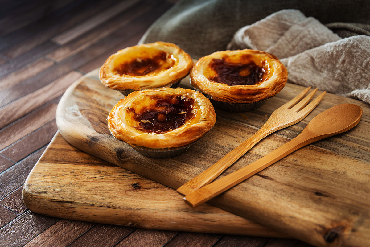 Close-up of pastéis de nata with cinnamon and coffee